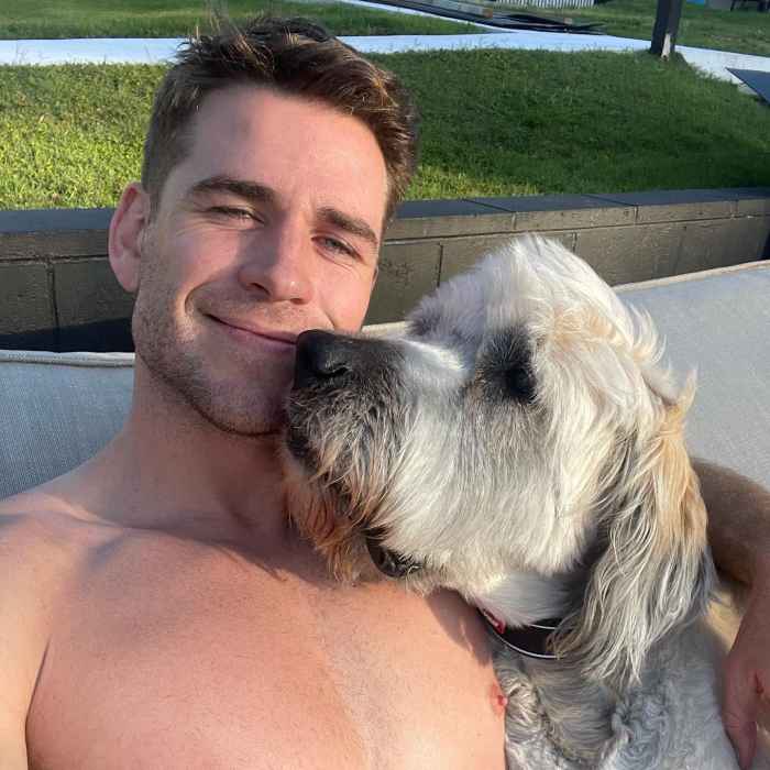Shirtless Liam Hemsworth cuddles - and kisses - his beloved dog Dora in an adorable photo