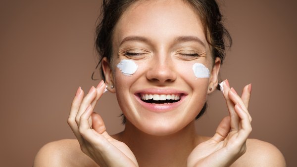Woman-Applying-Moisturizer-Stock-Photo