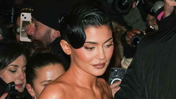 Kylie Jenner in Corset at Haute Couture Fashion Week hand to bodice