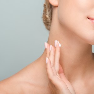 Woman-Applying-Neck-Cream-Stock-Photo