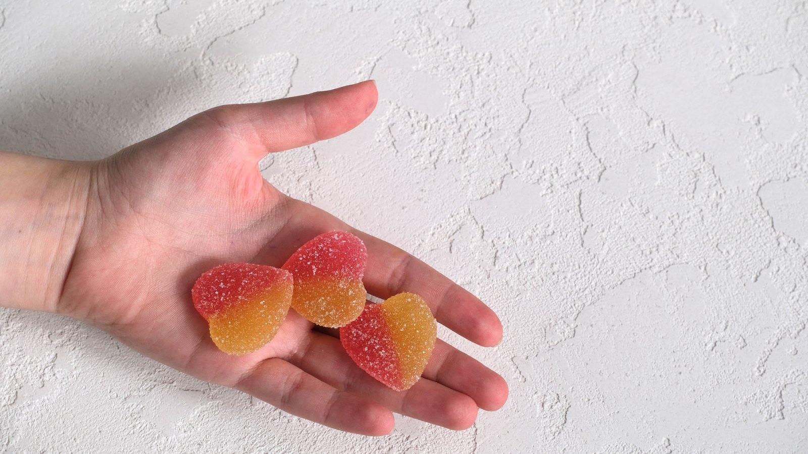 Two-Colored-Gummies-In-Hand-Stock-Photo
