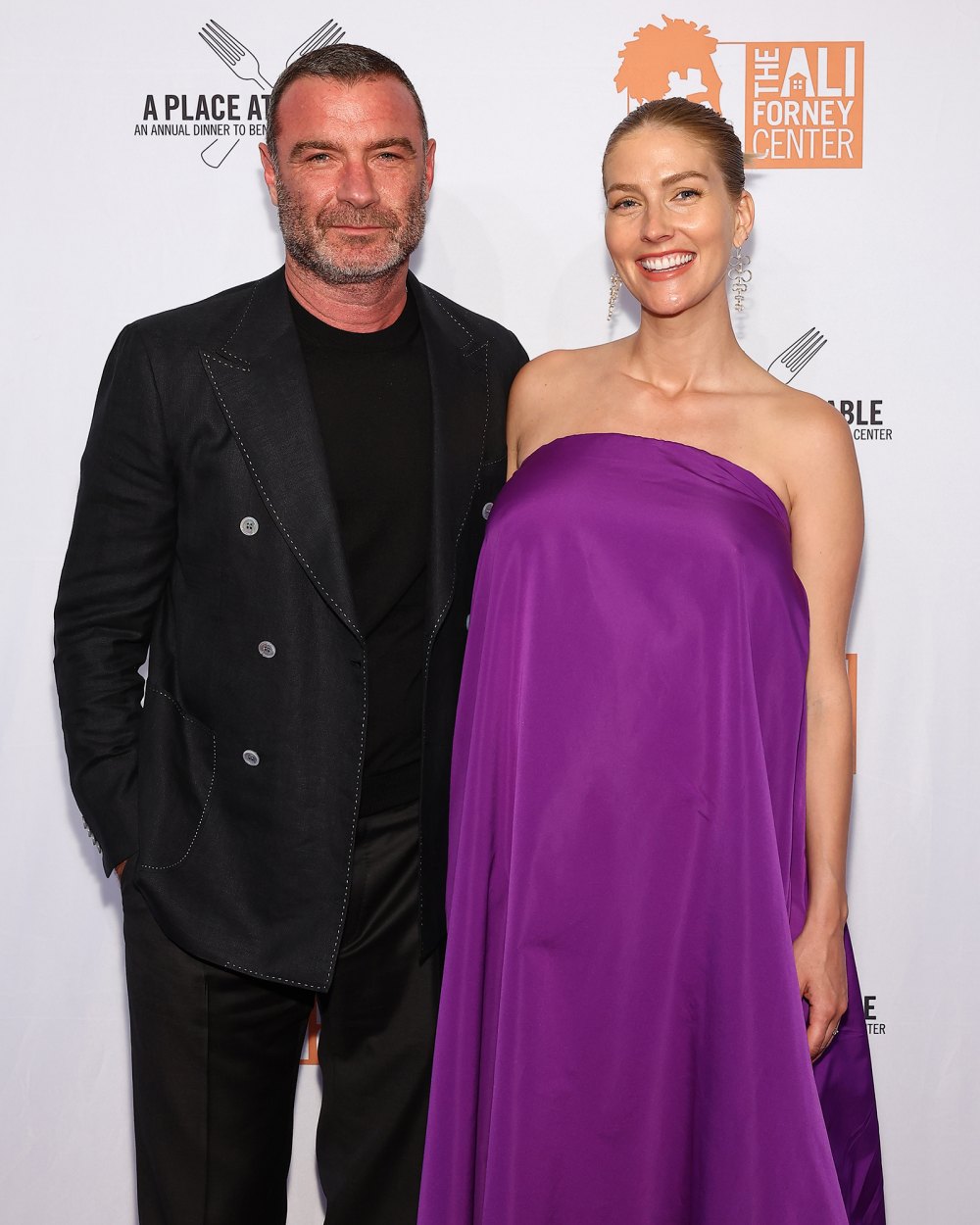 Liev Schreiber in Black Suit and Pregnant Taylor Neisen in Purple Dress Smile and Pose on Red Carpet for Ali Forney Center A Place At The Table Gala