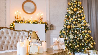 Christmas living room decoration, white and gold colors interior decoration background, Xmas home decoration with presents, christmas lights and tree indoors