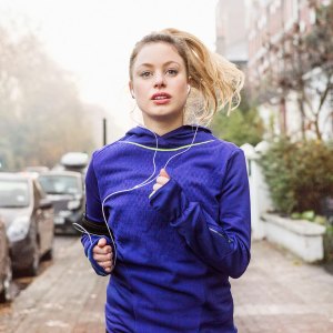 Female runner running down urban street.
