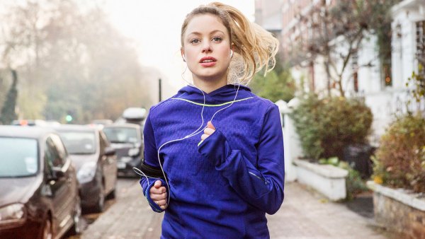 Female runner running down urban street.