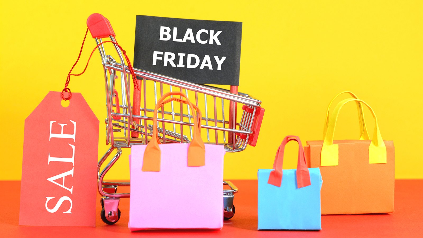 Black Friday Sale concept. Black Friday Sale text on black banner on a shopping cart with colorful shopping bags.