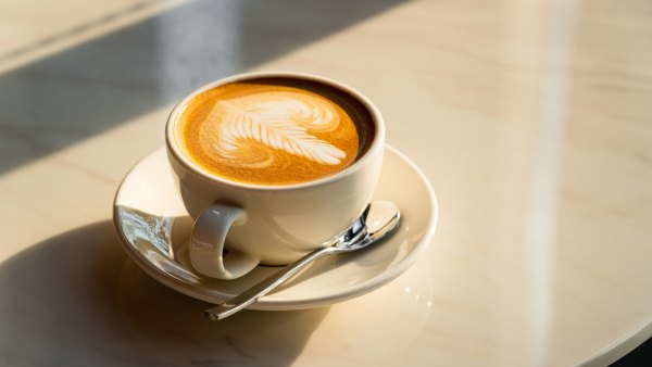 Feshly brewed latte coffee on a white table, a coffee drink made with espresso and steamed milk.