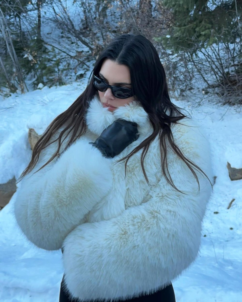 Kendall Jenner smiles softly while keeping warm in a white fur coat in Aspen