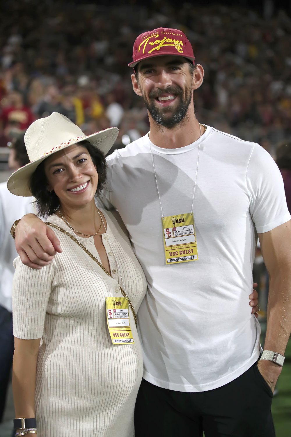 Michael Phelps and his wife Nicole Phelps, an USC graduate, pose for a photo on the USC sidelines during the Arizona State Sun Devils game.