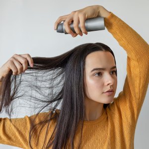 Woman applying hair spray