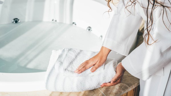 Woman holding white bath towels.