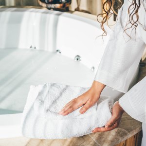 Woman holding white bath towels.