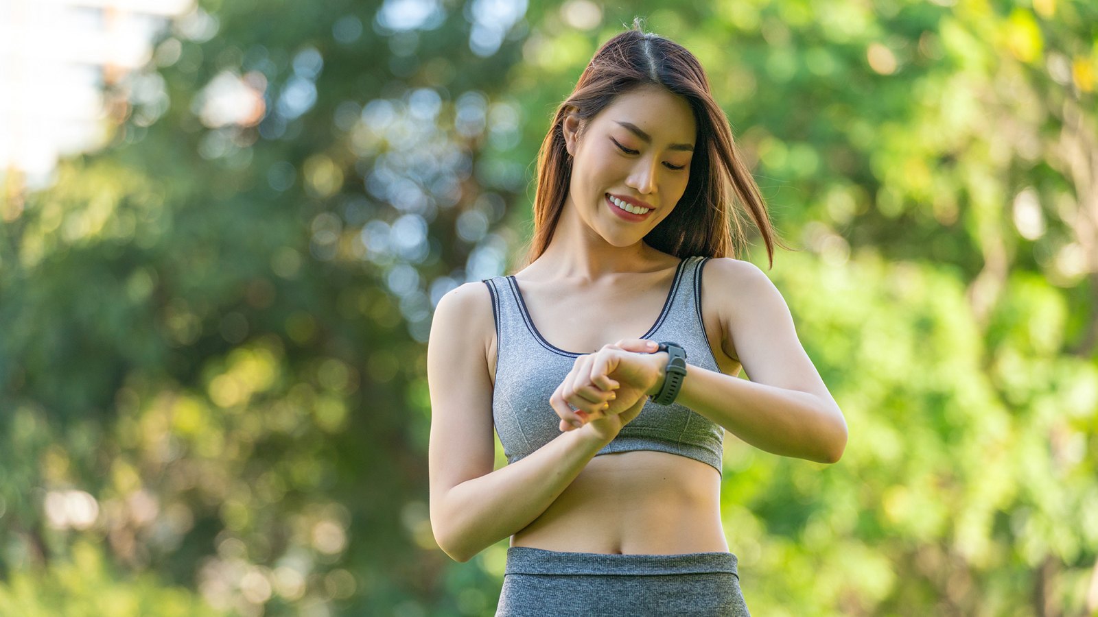 Portrait of a Young Woman in Sportswear and Smartwatch Enjoying Healthy Living and Exercise, Radiating Happiness and Positivity During Leisure Exercise in a Public Park at Sunset. Positive Vibes. Enjoying Healthy Living And Outdoor Wellbeing. Smart Wellness.