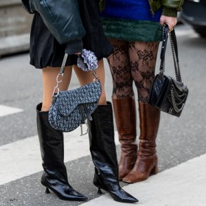 COPENHAGEN, DENMARK - JANUARY 31: A guest wears Dior bag & a guest wears Chanel bag, black boots, brown boots, tights outside The Garment during the Copenhagen Fashion Week AW24 on January 31, 2024 in Copenhagen, Denmark. (Photo by Christian Vierig/Getty Images)