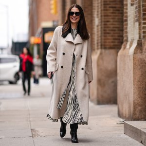 A guest wears sunglasses, a beige long fabric coat , a black and white striped / zebra print long dress, black leather boots, outside Proenza Schouler , during New York Fashion Week, on February 10, 2024 in New York City. (Photo by Edward Berthelot/Getty Images)
