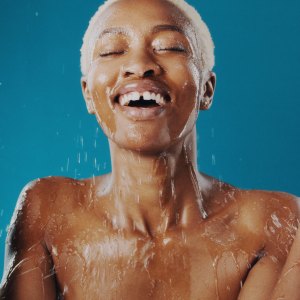 Cropped shot of a beautiful young woman splashing water over her face