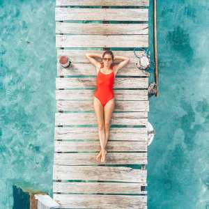 Aerial shot of woman relaxing in a water bungalow