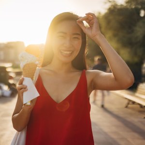 Portrait of a smiling woman eating ice cream and looking directly at the camera