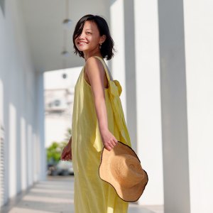 A cheerful solo woman traveler, looks back with a beautiful smile while joyfully exploring Georgetown, Penang.