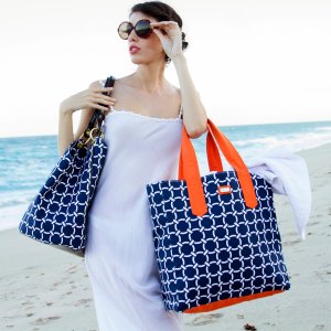 Beautiful woman on beach with sunglasses and fashionable bags on beach