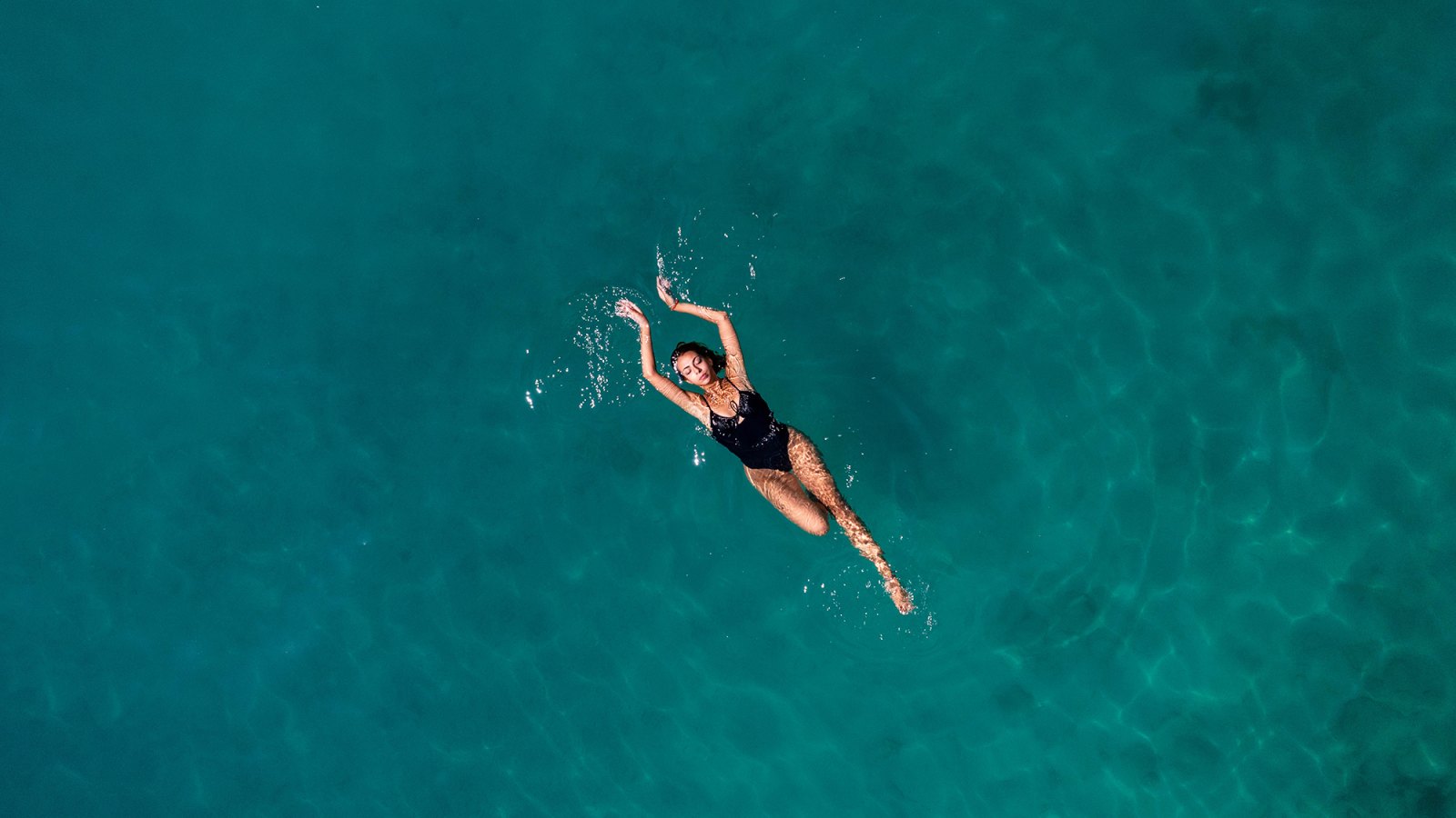 Aerial View Young Woman is Floating on Navy Blue Sea