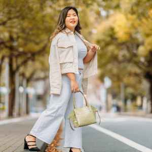 A full size portrait of a young woman in the street in autumn.