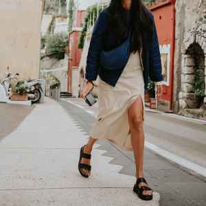 A young woman walks through a narrow street of Positano, on the Almalfi Coast in Italy.
