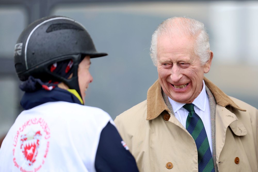 King Charles smiles as he chats with a jockey