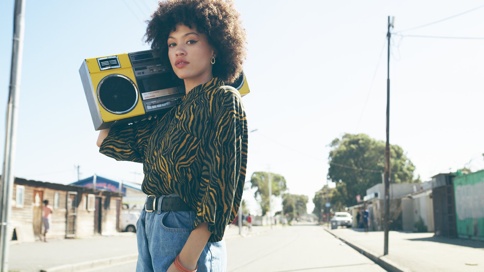 Shot of an attractive young woman listening to music on a boombox in an urban setting