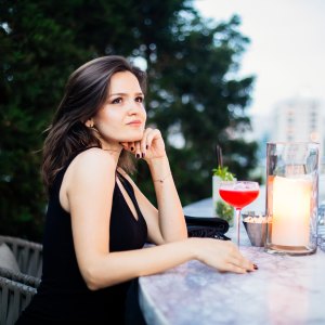 Beautiful woman drinking pink cocktail at roof bar