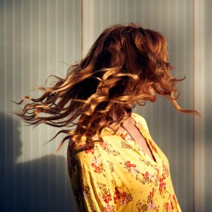 Red-haired woman throwing her hair in the evening sun