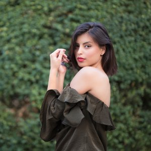 Fashion portrait of a beautiful, young woman wearing off - shoulder shirt.