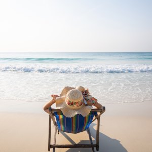 Woman relaxing in lawn chair on beach