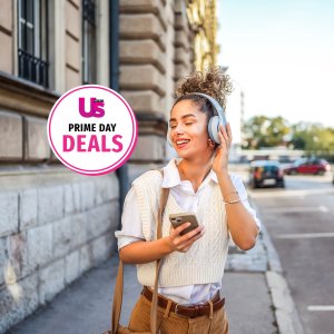 Happy smiling woman enjoying while listening to music in the city