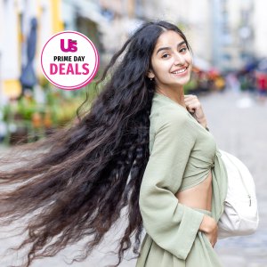 Indian student charms with a radiant smile as she enjoys urban exploration and sightseeing on a sunny day in the city.