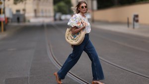 woman wearing jeans, floral blouse and woven bag