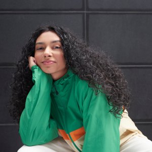 Portrait of young woman against black background