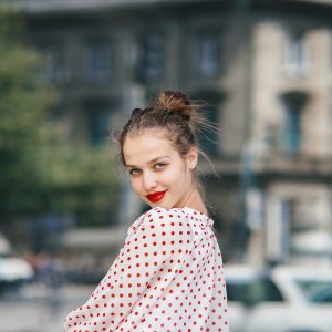 Young beautiful woman in the city wearing red lipstick