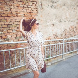 Woman enjoying outside and walking near the old brick wall.