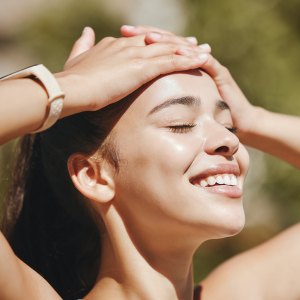 Face, relax and happy woman in sunshine, outdoor fresh air and peaceful break for mental health, wellness and body. Summer, happiness and smile latino girl relax in nature, park rest and calm freedom