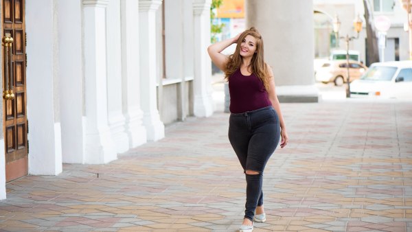 Pretty young woman walking on the city street. Casual fashion, plus size model. xxl women on nature