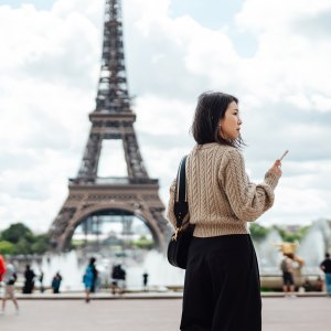 Young business woman working on smartphone during business trip. Business and leisure travel concept.