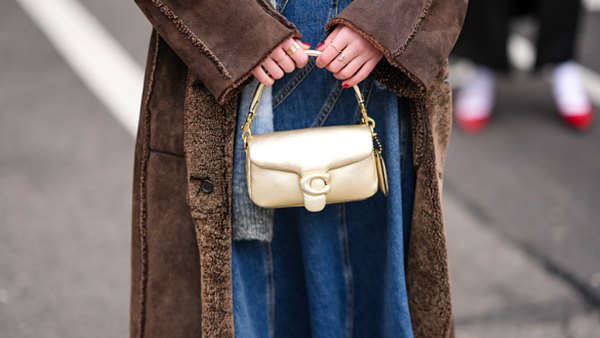 woman holding golden coach bag