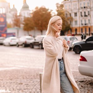 Young thoughtful woman walking on street in city