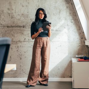 A businesswoman reading something on a tablet pc in her hands.