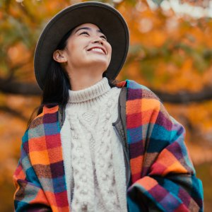A portrait of a young fashionable and beautiful woman in nature in autumn.