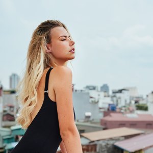 Shot of an attractive young woman posing in a black bodysuit on her balcony