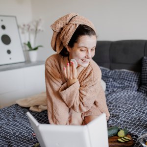 Portrait of woman having skin care routine in bed