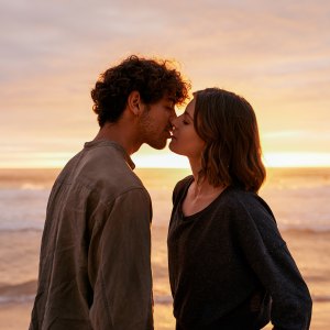 Shot of an affectionate young couple kissing on the beach at sunset