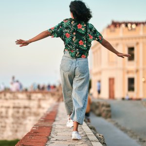 Woman walking on wall seen from behind in Cartagena, Colombia